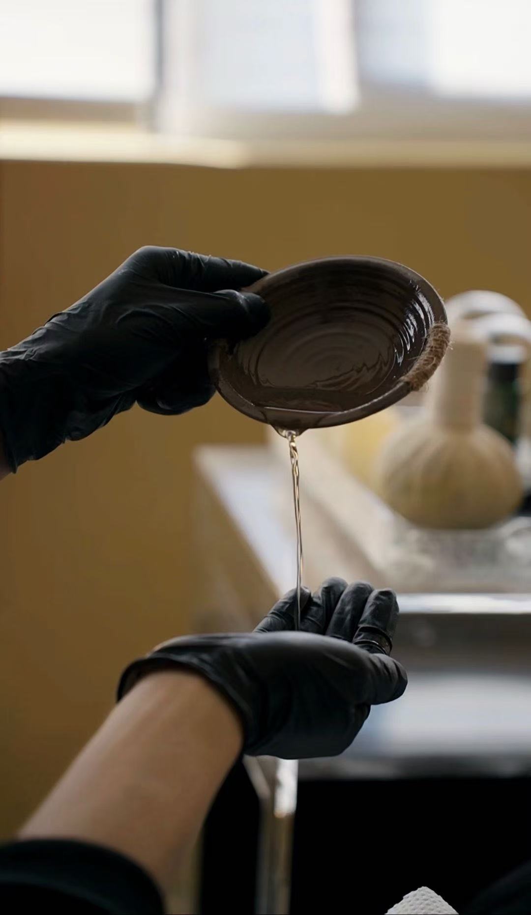 Warm herbal oil pouring for therapeutic scalp massage at Bellevue head spa